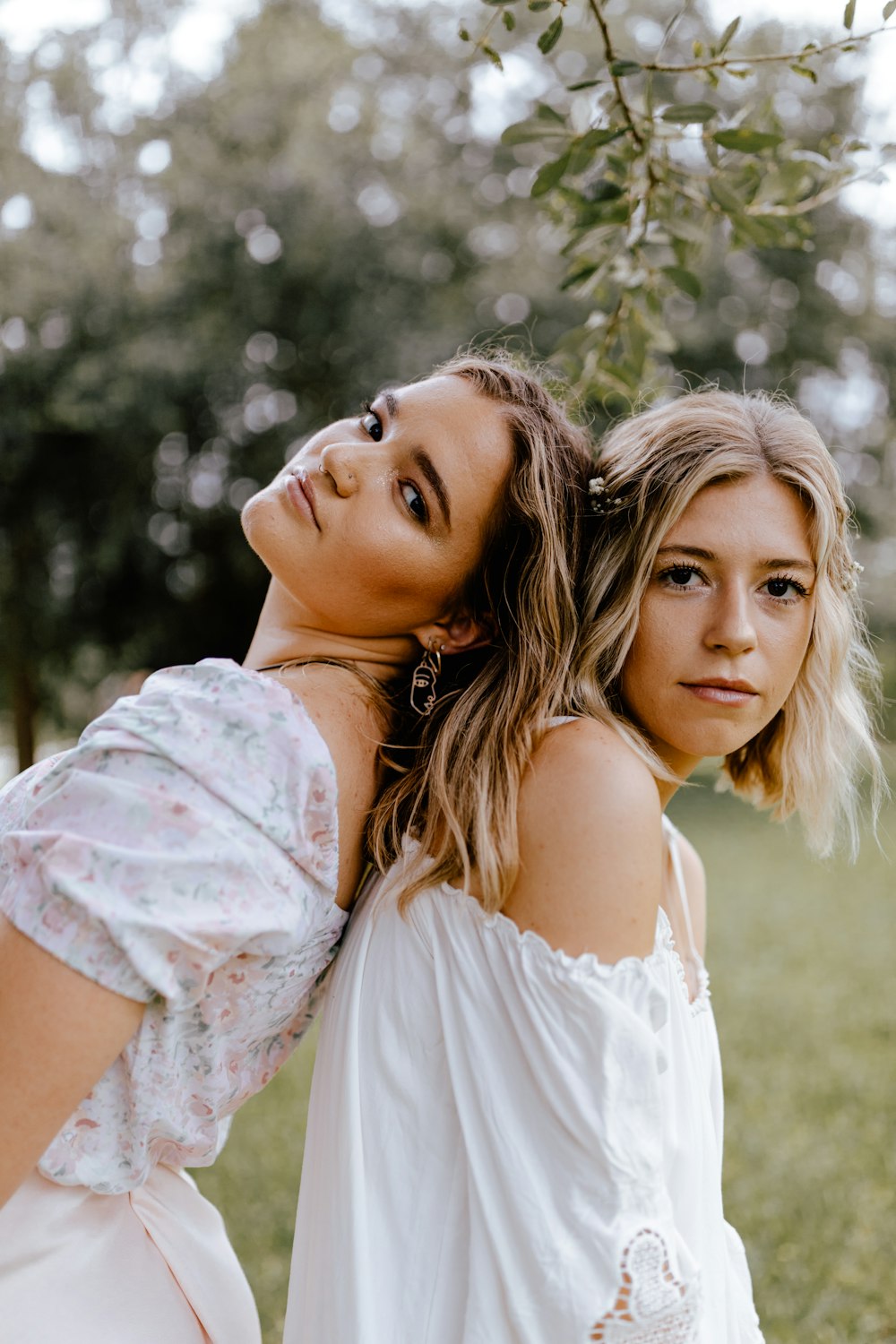 woman in white floral dress hugging woman in white dress