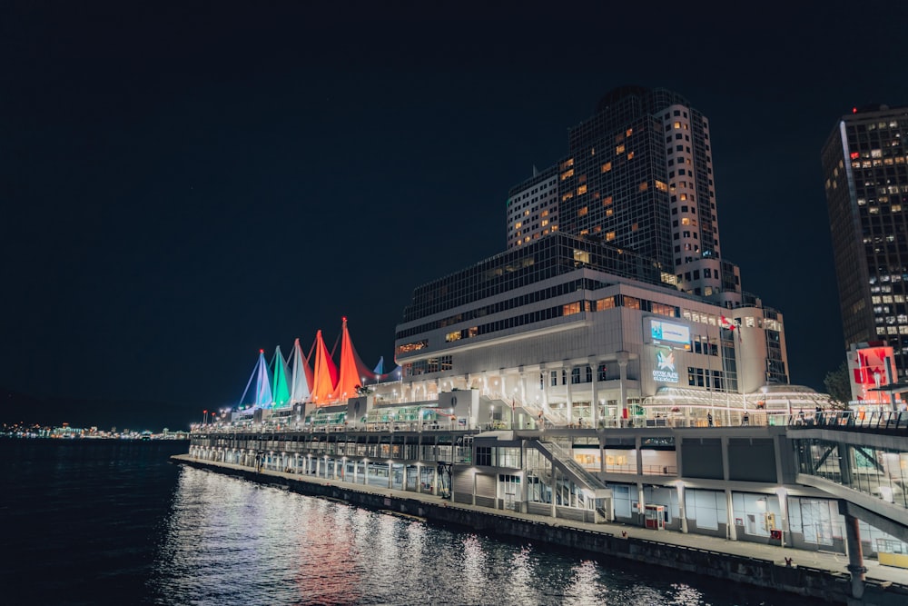 white and black ship on sea near city buildings during night time