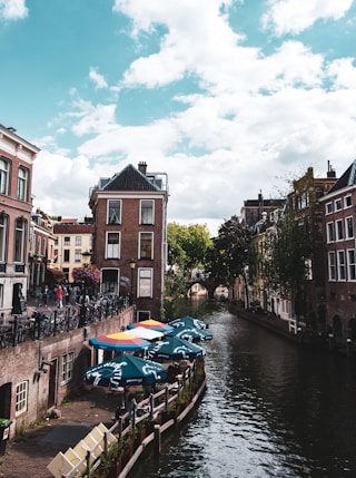 blue boat on river between buildings during daytime