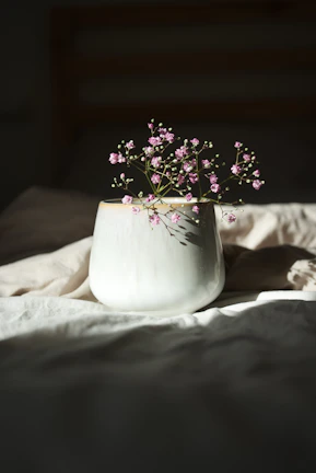 Elegant ceramic vase with a matte finish, surrounded by fresh wildflowers in soft natural light.
