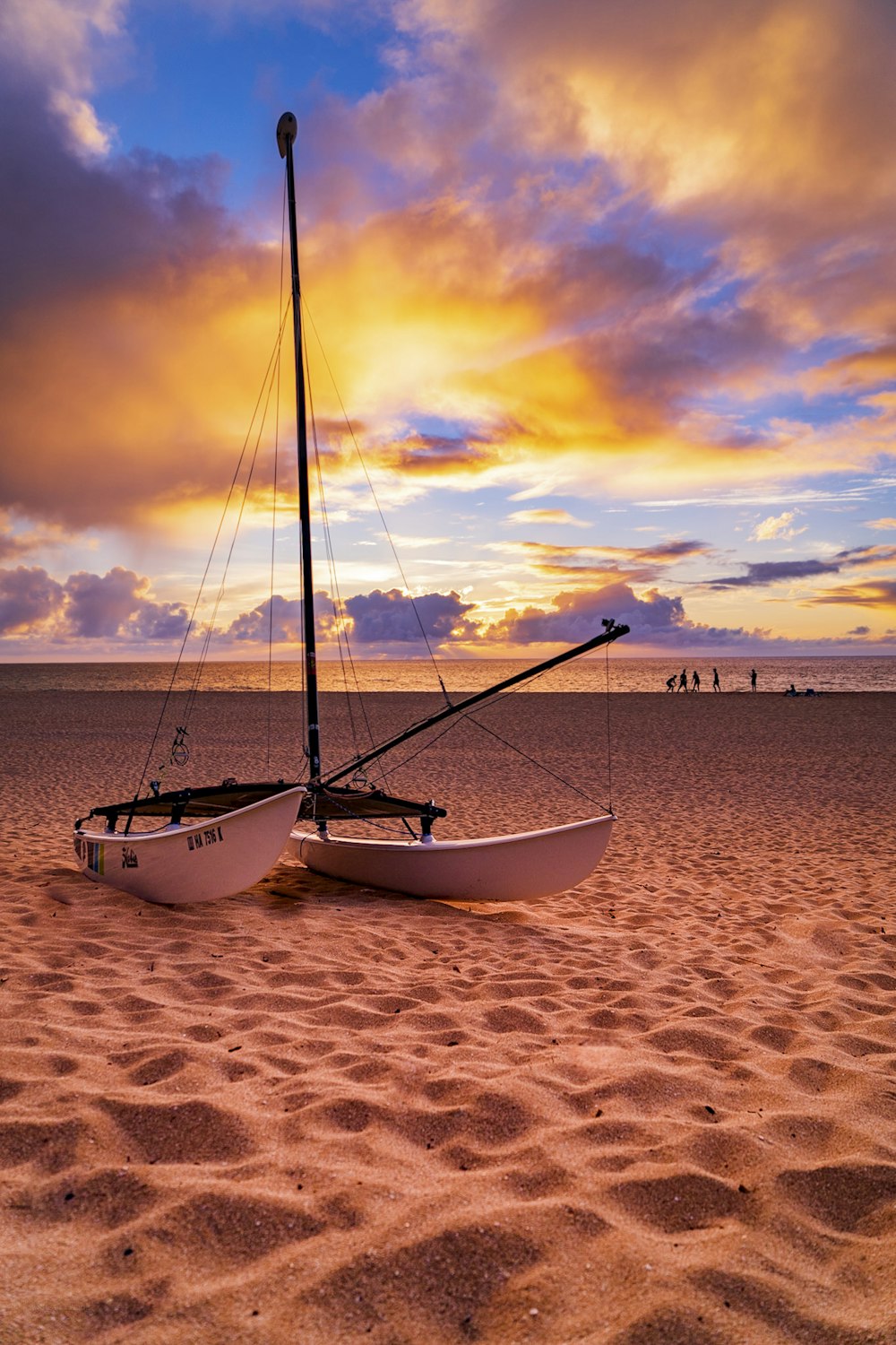 white boat on brown sand during sunset
