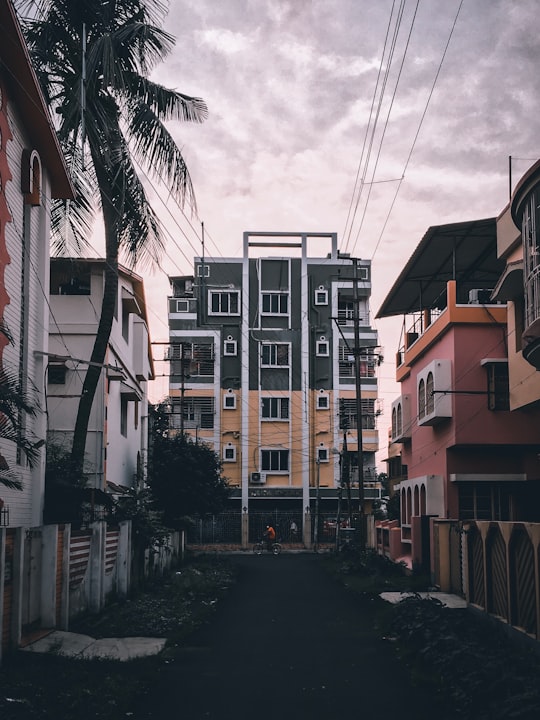 brown and white concrete buildings under white clouds during daytime in West Bengal India