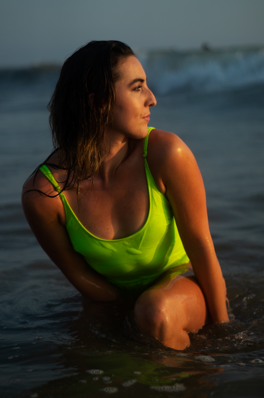 woman in green tank top sitting on water during daytime