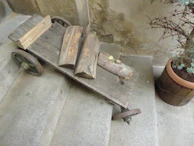 A sturdy utility cart made from reclaimed wood and metal wheels, holding glass candle stands.