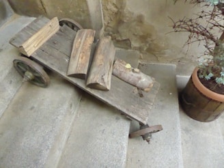 A rustic wooden kitchen island cart with a natural finish, showcasing its sturdy wheels and spacious countertop.