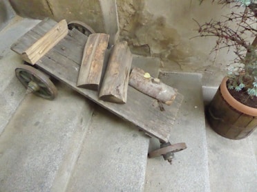 A rustic wooden kitchen island cart with a natural finish, showcasing its sturdy wheels and spacious countertop.