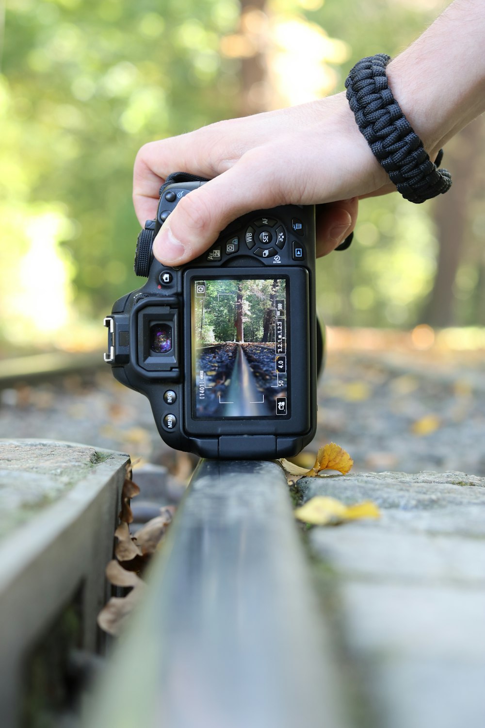 Persona che tiene in mano una fotocamera DSLR nera