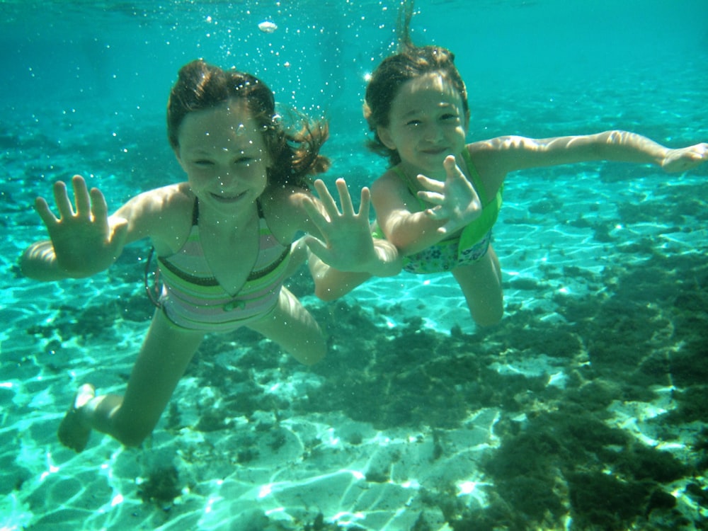 2 girls in green bikini swimming in the water