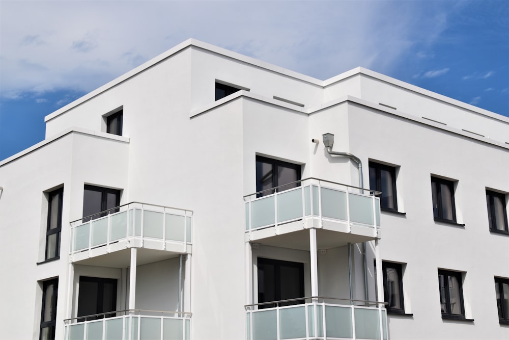 Weißes Betongebäude unter blauem Himmel tagsüber