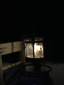 A softly glowing lantern resting on an open map under warm light.