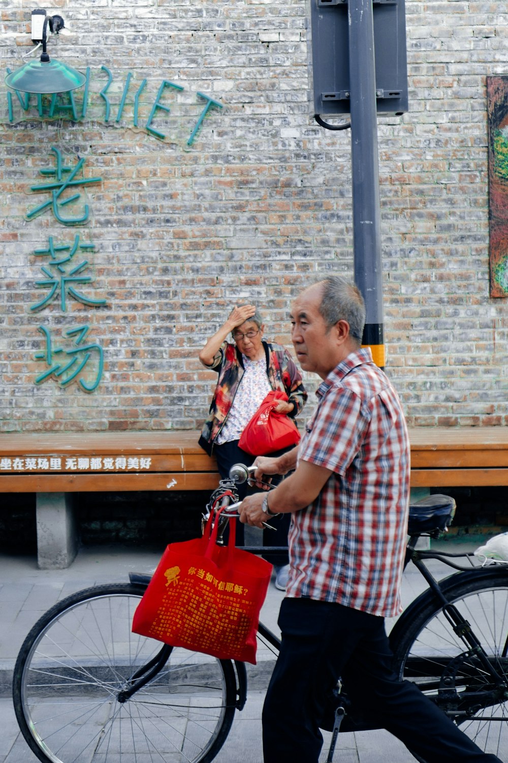 man in red and white plaid button up shirt holding red plastic bag