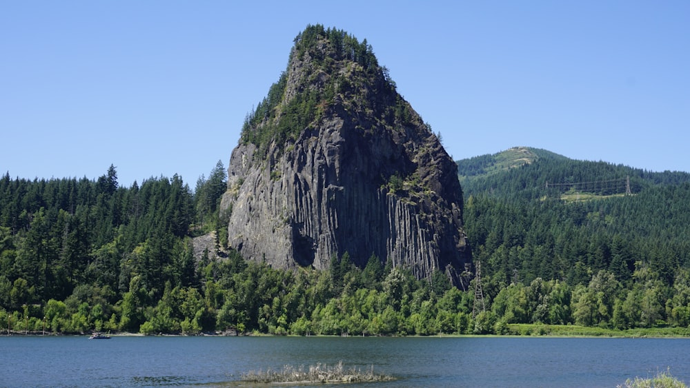 green and brown mountain beside body of water during daytime