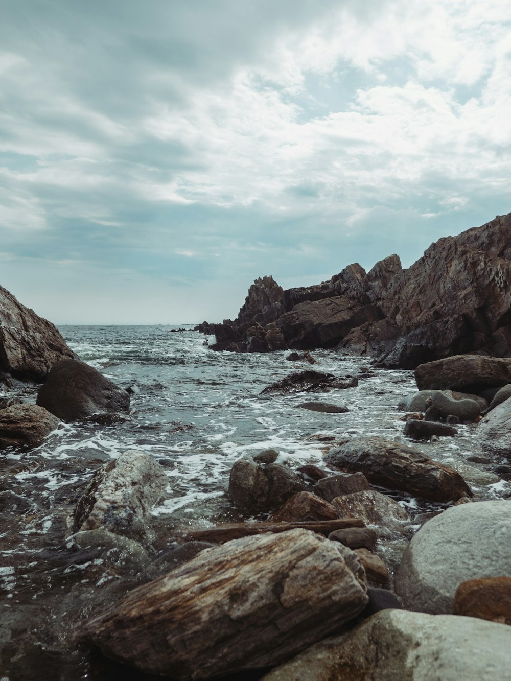 brown rocky mountain beside body of water during daytime