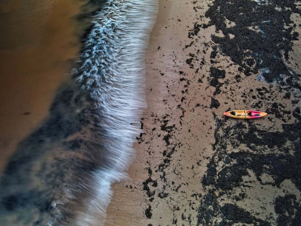 Planche de surf jaune et noire sur sable brun