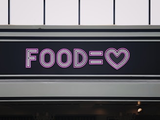 a neon sign that says foodie with a heart