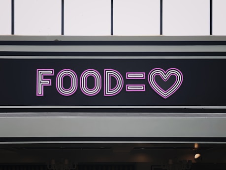 a neon sign that says foodie with a heart