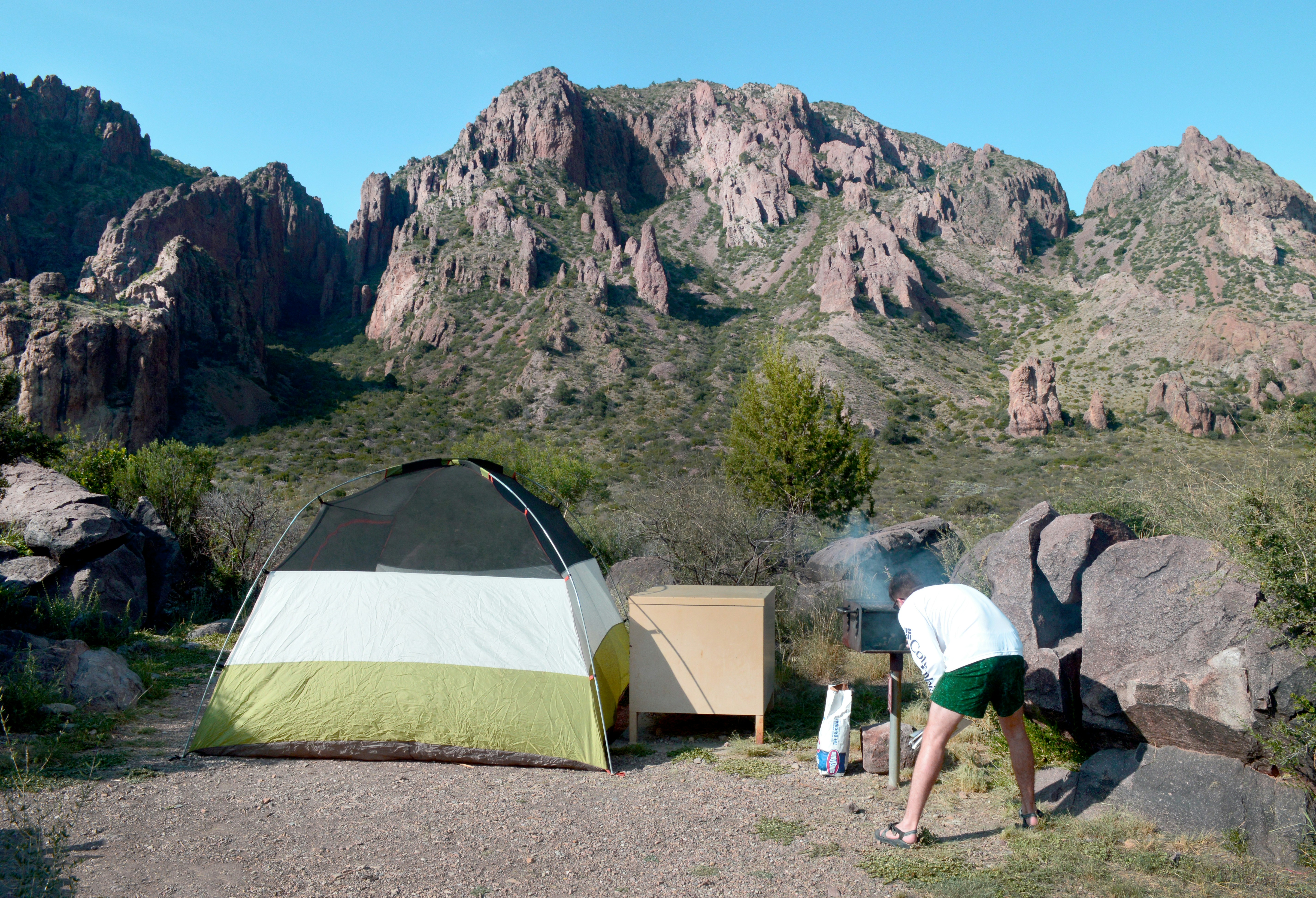 man in white t-shirt standing near yellow tent during daytime, 