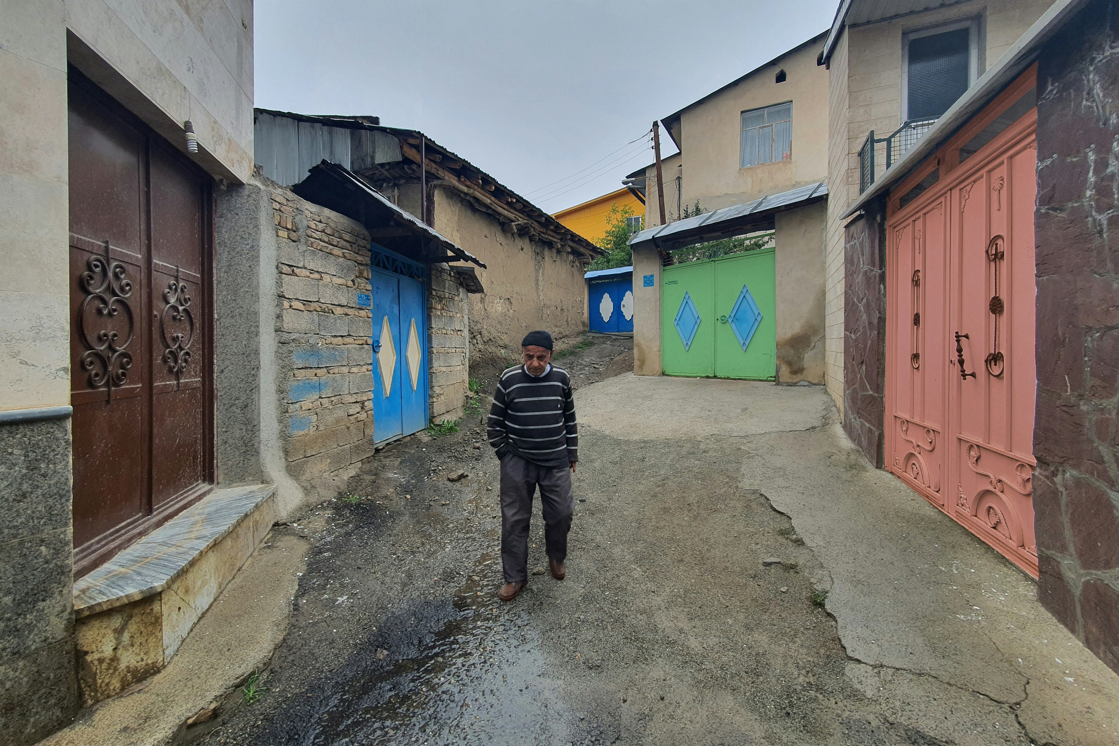 Lerik, Azerbaijan (longevity village) - A Man walking down the alley between colorful doors