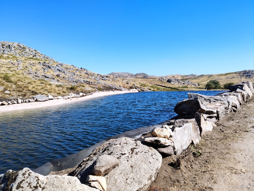 gray rocky shore near body of water during daytime