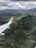 Aerial view of a charter aircraft flying over lush green landscapes.