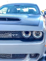 Close-up of a gleaming Dodge Challenger SRT hood with sharp black-and-white contrast.