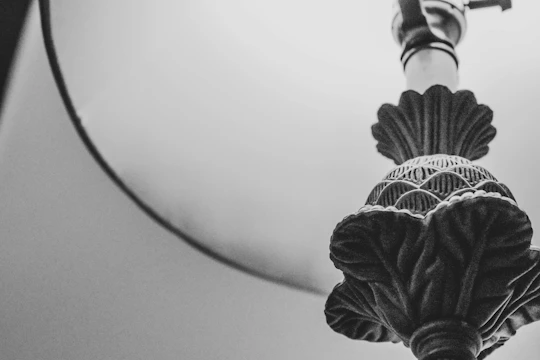 Close-up of a sleek lamp featuring intricate Christian motifs carved into the metal.