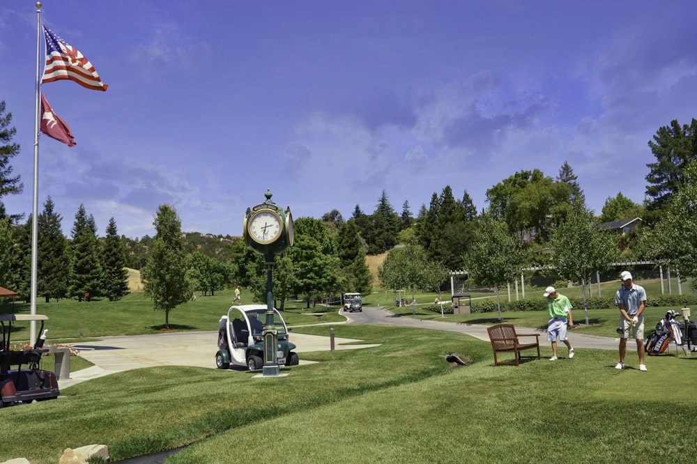 people sitting on bench on green grass field during daytime