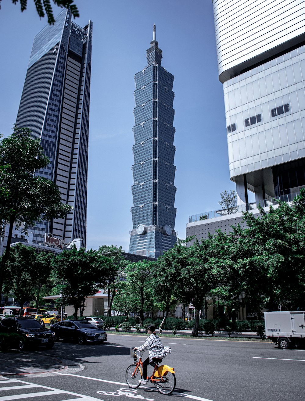 cars parked on side of the road near high rise building during daytime