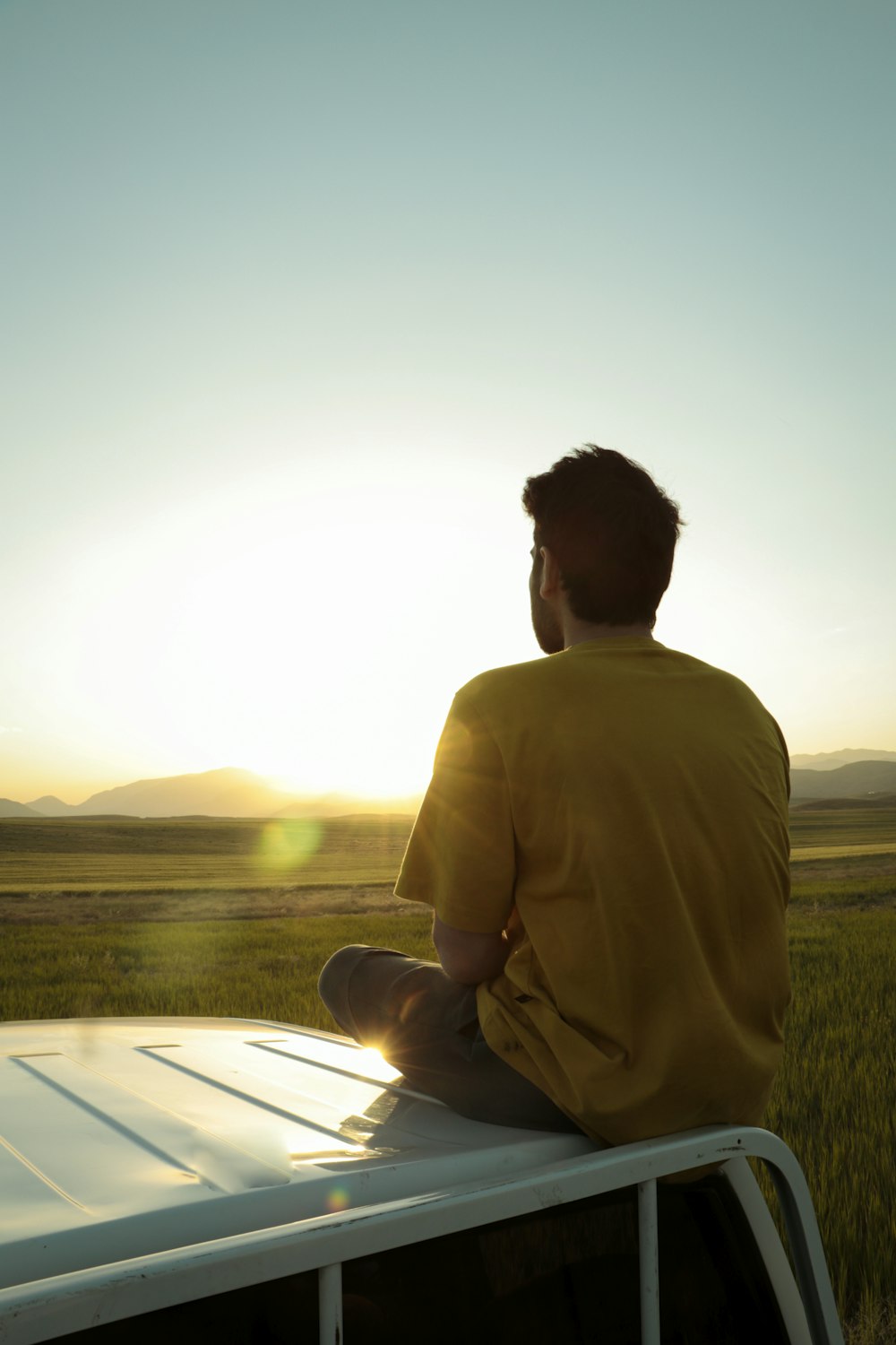 man in brown long sleeve shirt sitting on green grass field during daytime