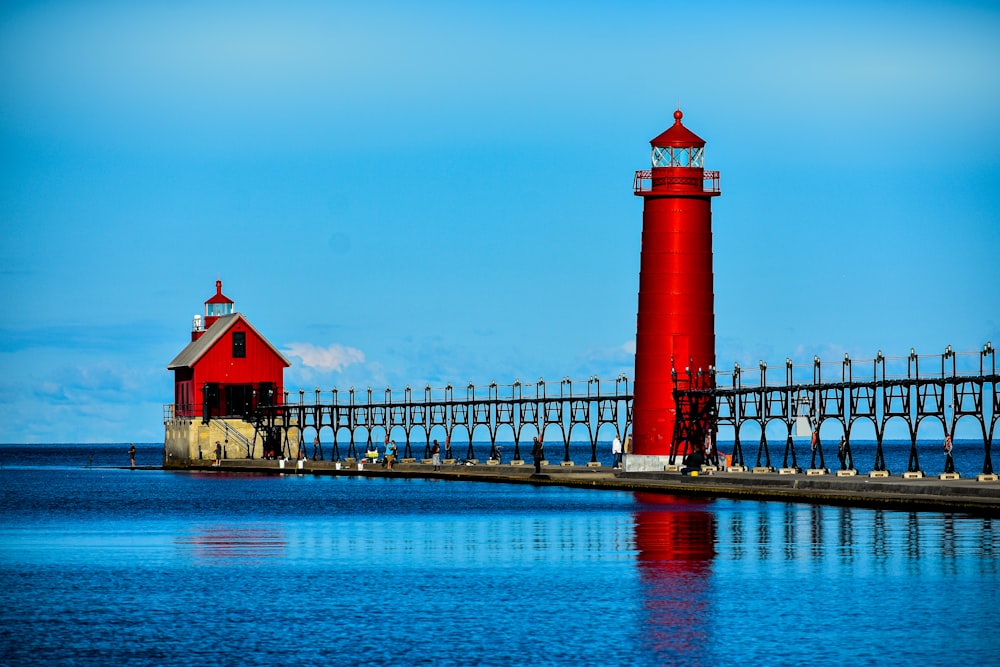 red and white lighthouse near body of water during daytime