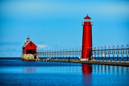 red and white lighthouse near body of water during daytime
