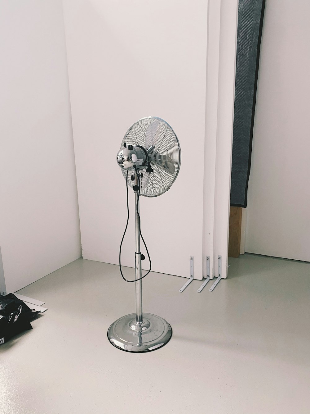 silver stand fan on brown wooden table
