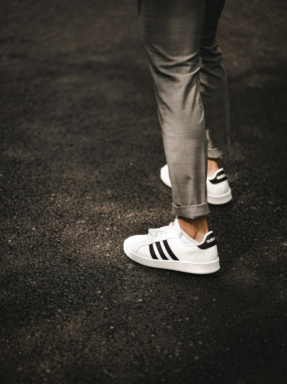 person in gray pants wearing white and black sneakers