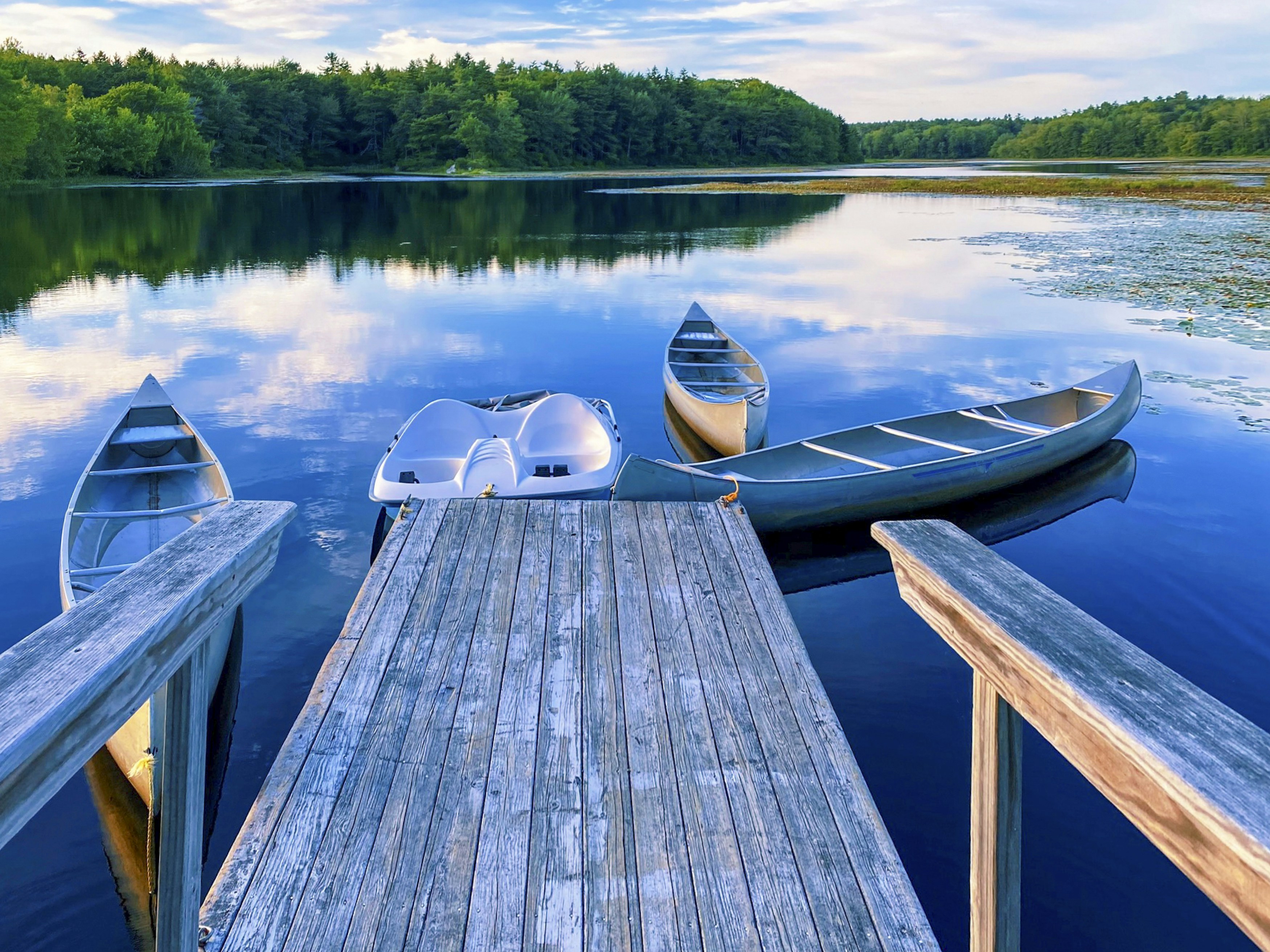 Canoes on a lake dock in Maine.
