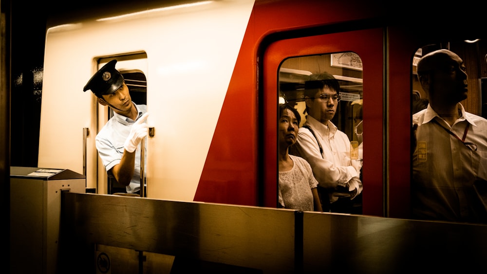 man in white dress shirt and black pants sitting on train seat