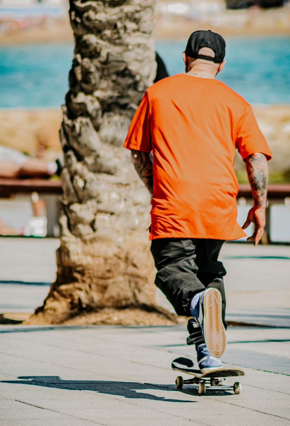 man in orange shirt and black shorts running on gray concrete road during daytime