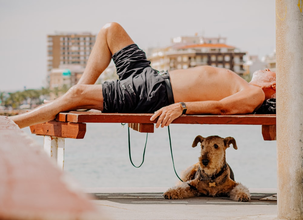 person in black shorts sitting on brown wooden chair