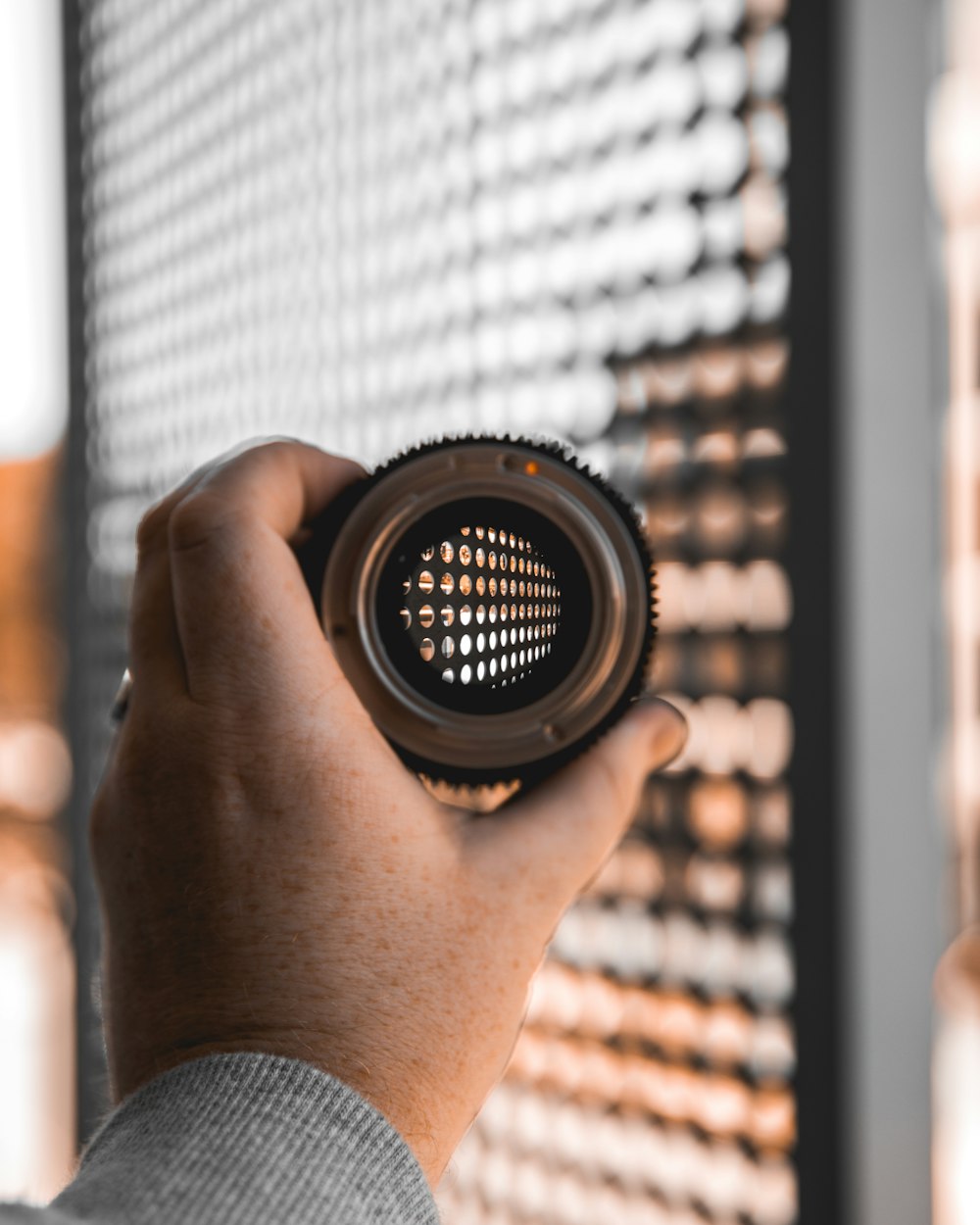 person holding black camera lens