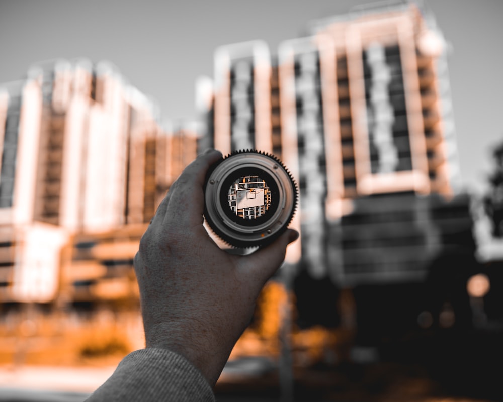 person holding black and silver round digital watch