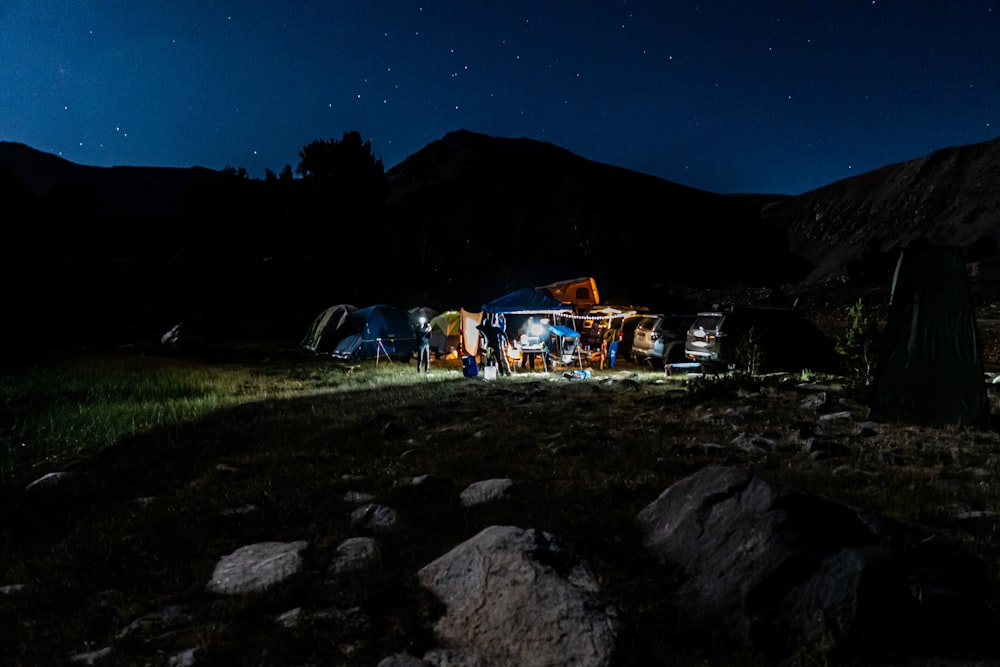 Gente acampando en un campo de hierba verde durante la noche