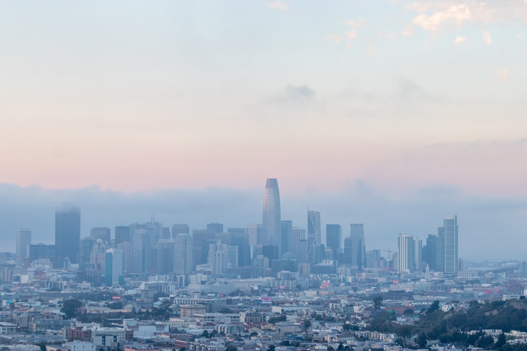 city with high rise buildings under white sky during daytime