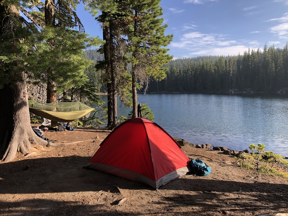 red and black tent near lake during daytime