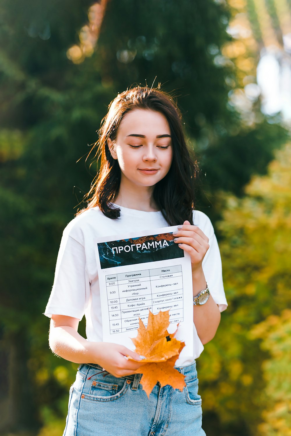 woman in white crew neck t-shirt holding white book