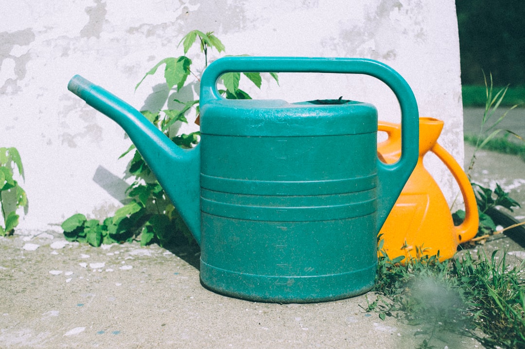 green watering can on gray concrete floor