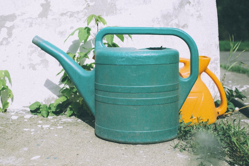 green watering can on gray concrete floor