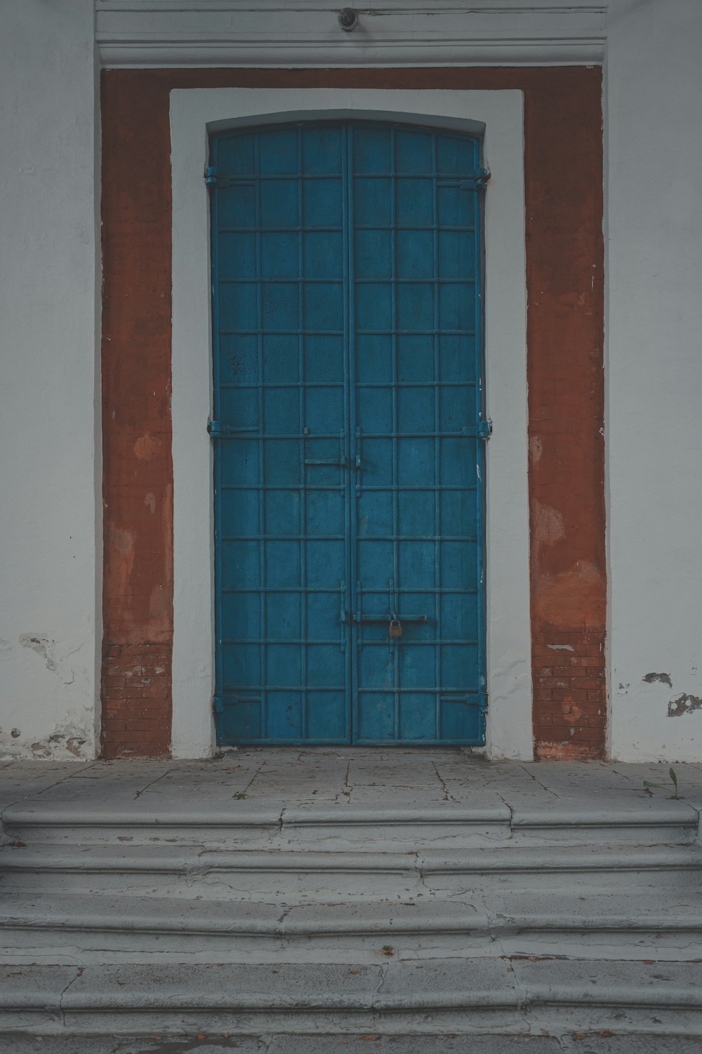 blue wooden door on white concrete wall