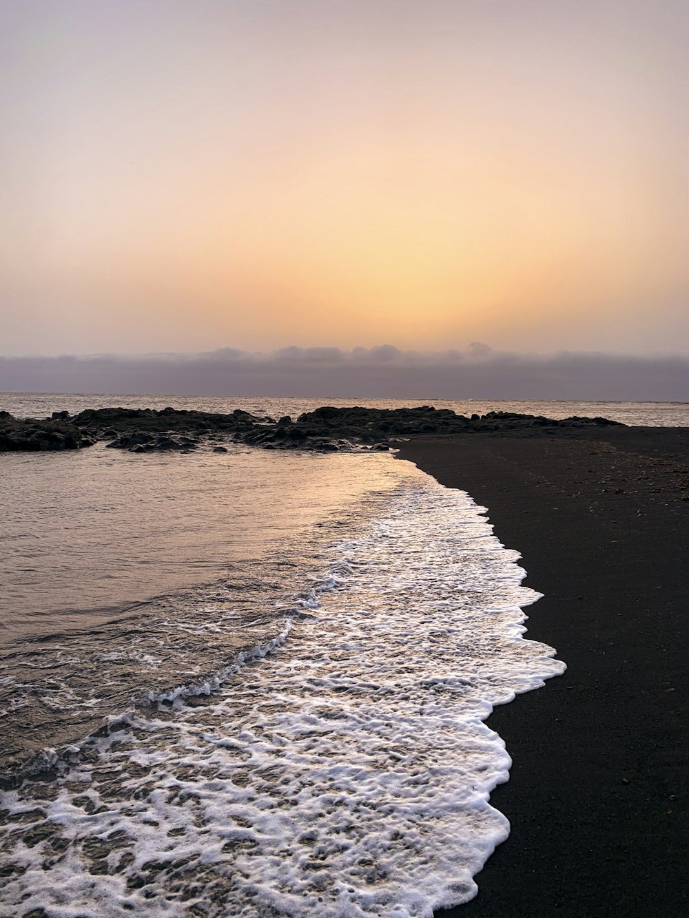 Les vagues de l’océan s’écrasent sur le rivage au coucher du soleil