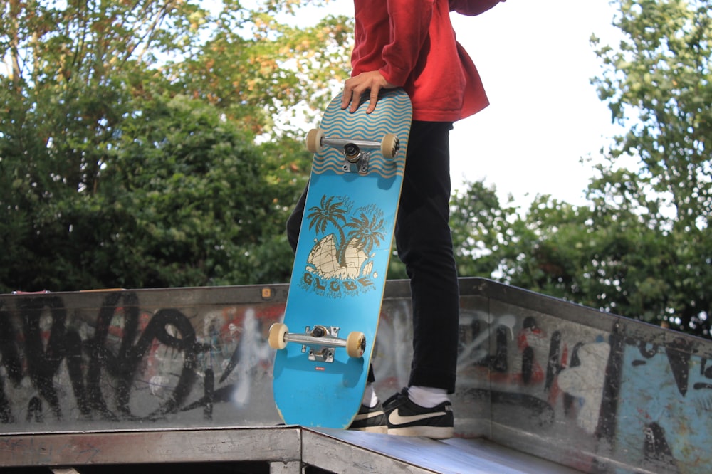 woman in red shirt and blue pants standing on gray concrete floor