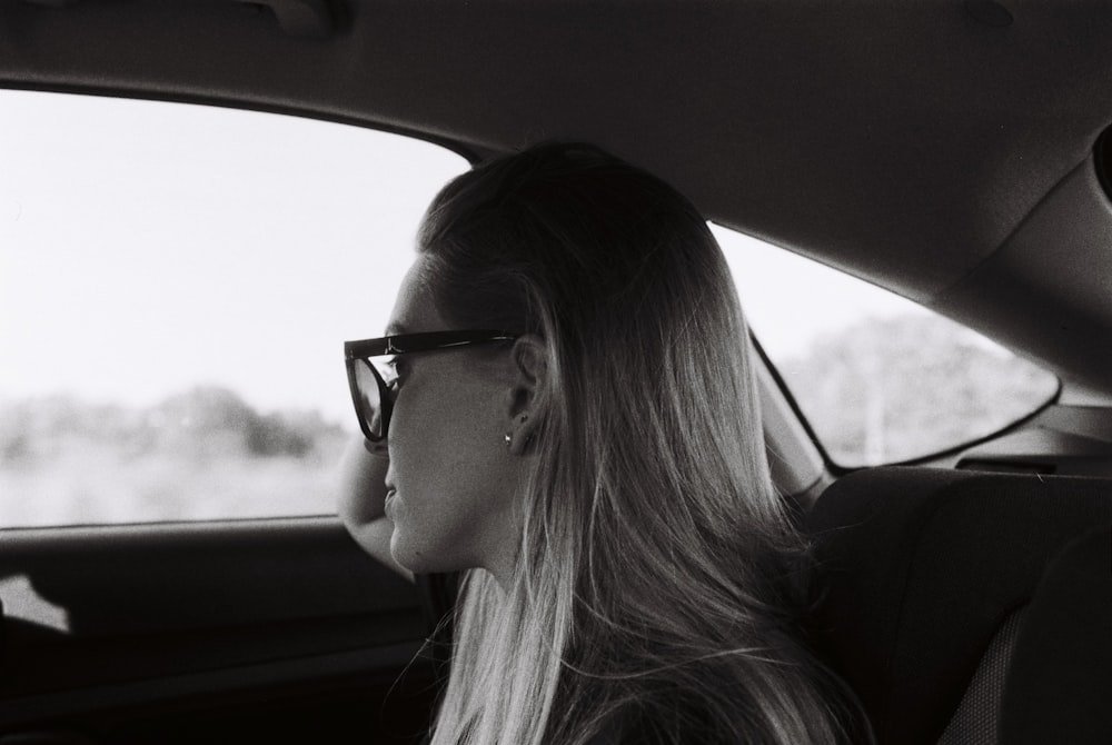 a woman sitting in the back seat of a car