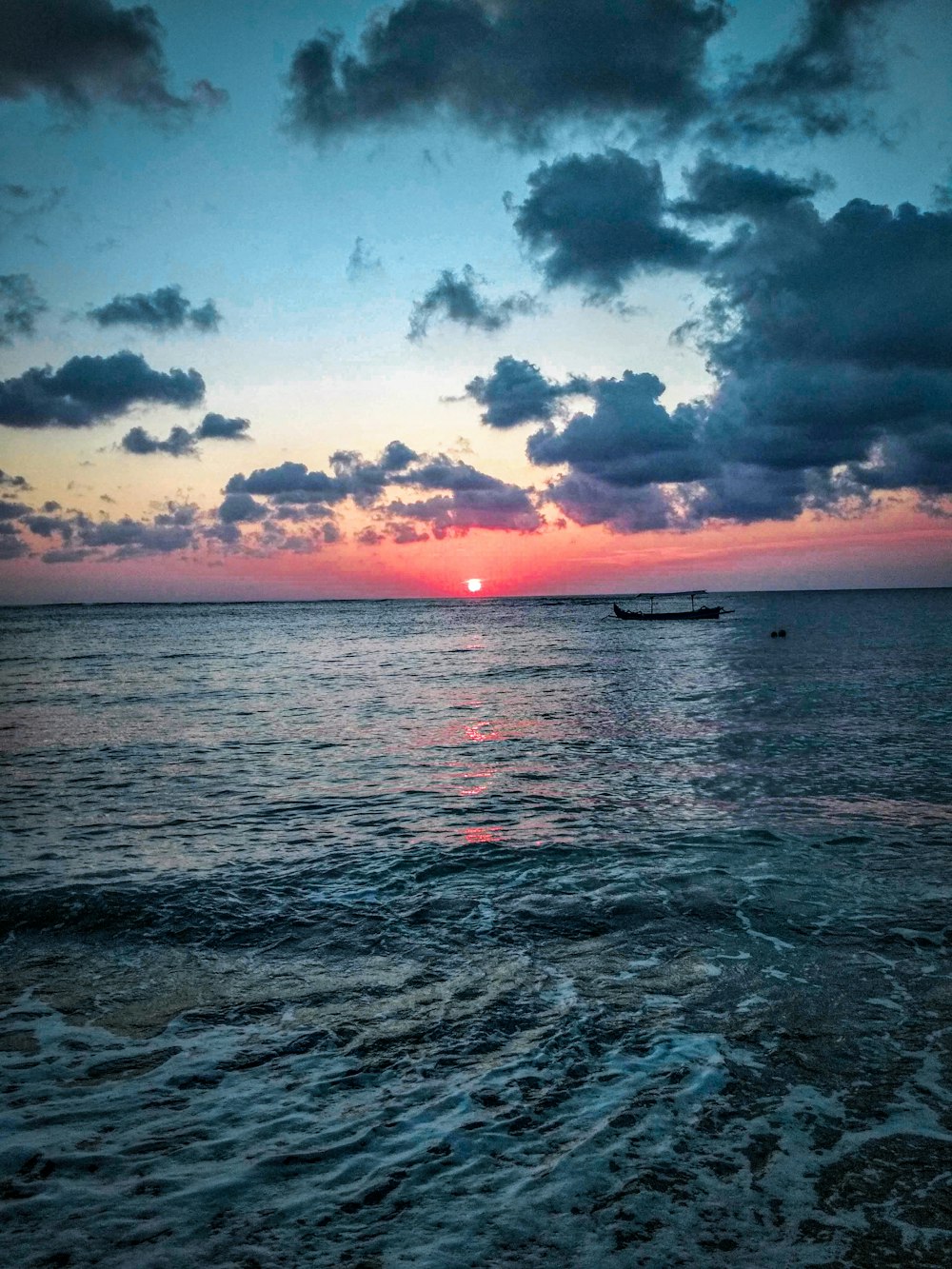 body of water under cloudy sky during sunset